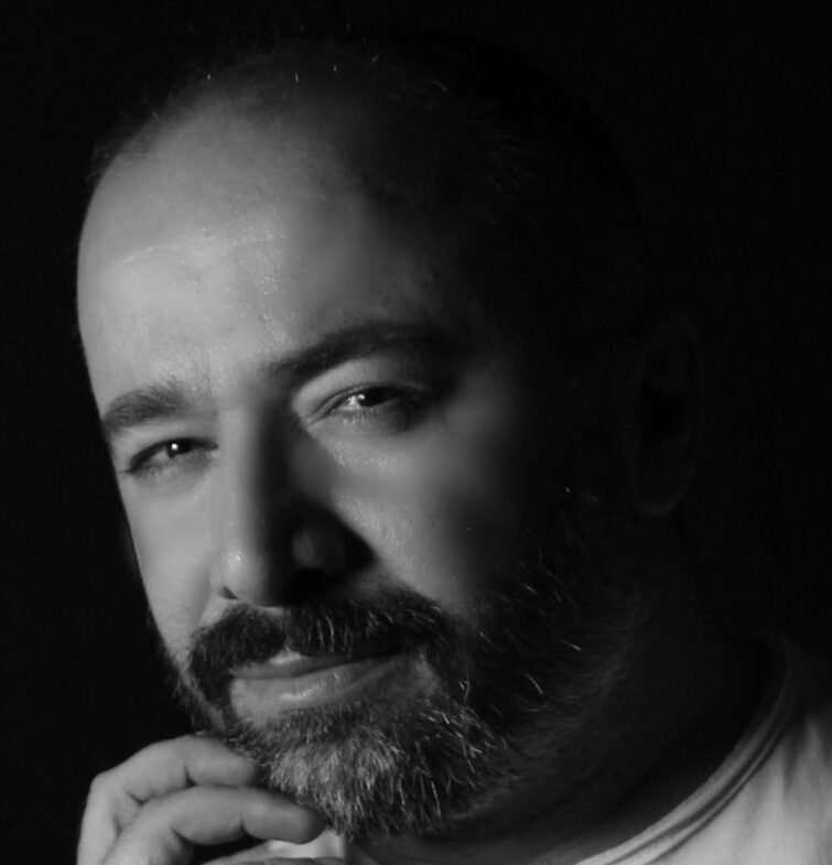 Dramatic black and white portrait of a thoughtful man in studio lighting.